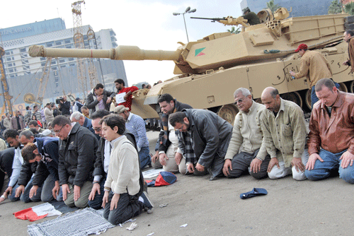 Protesters pray in front of a tank in Cairo's Tahrir Square on Jan. 30. (Photo: Iman Mosaad