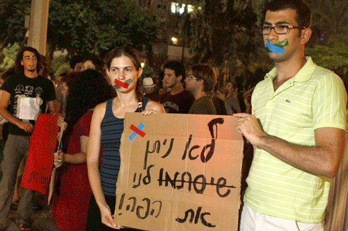 Two among dozens of demonstrators on Monday night in Rabin Square in Tel Aviv protesting the new anti-boycott law enacted by Israel's Knesset. (Photo: Uri Lenz/Flash 90)