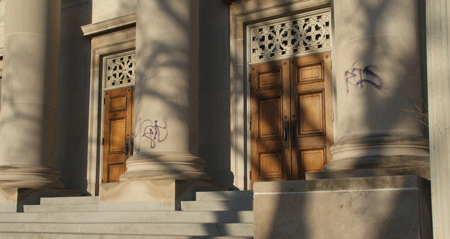 A lone vandal spray-painted purple letters on all sides of the Temple Israel building, including the columns facing Hennepin Avenue.