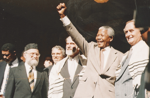 Nelson Mandela salutes the crowd at the Green and Sea Point Hebrew Congregation in Cape Town on a visit shortly after being elected South Africa’s president in 1994. Joining Mandela, from left, are Rabbi Jack Steinhorn; Israel’s ambassador to South Africa, Alon Liel; Chief Rabbi Cyril Harris; and Mervyn Smith, chairman of the South African Jewish Board of Deputies. Photo courtesy of SA Rochlin Archives, SAJBD 