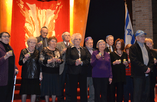 The 2014 Twin Cities Yom HaShoah (Holocaust Remembrance Day) Commemoration took place Sunday night at Temple of Aaron Synagogue in St. Paul. At the conclusion of the program, survivors assembled on the bima, holding yahrzeit candles, and sang "Hatikvah" and "America the Beautiful." The event is sponsored by the Jewish Community Relations Council of Minnesota and the Dakotas (JCRC), Children of Holocaust Survivors Association in Minnesota (CHAIM), Temple of Aaron Synagogue, Jewish Federation of Greater St. Paul and Minneapolis Jewish Federation.