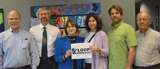 Brian Hoffman (second from left), director of inspections for the City of St. Louis Park, poses with Loop Minnesota members (l to r): Ross Hammond, Monique Hammond, Kim Fishman, Rick Nelson and Dick Davis following the installation of a hearing loop at the St. Louis Park City Council Chambers. (Photo: Courtesy of Kim Fishman)