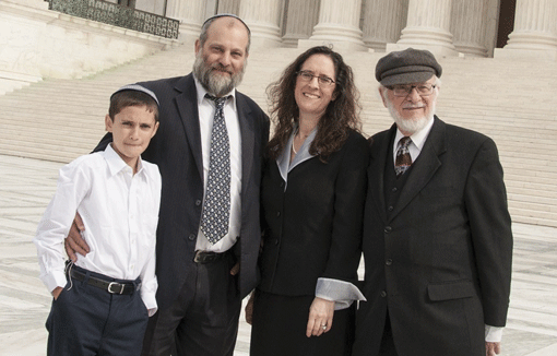 Menachem Zivotofsky (left) and his father Ari posing in front of the Supreme Court with their attorney, Alyza Lewin, and Lewin’s father, Nathan, on Nov. 3, 2014. (Photo: Rikki Gordon Lewin)