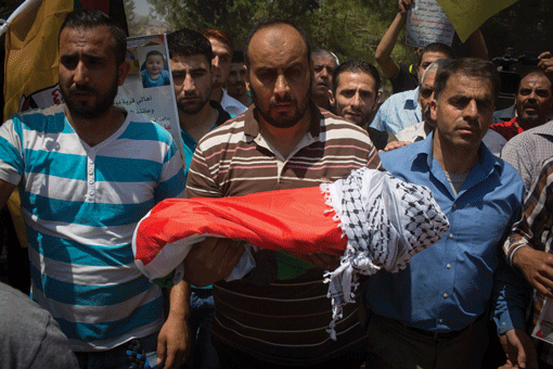 The body of 18-month-old Ali Saad-Dawabsheh, surrounded by relatives, is carried at his funeral in the Palestinian village of Duma, in the West Bank, on July 31, 2015. (Photo: Oren Ziv / Getty Images)