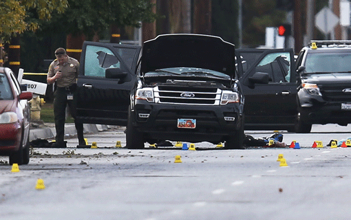 Law enforcement officials investigating the Ford SUV at the scene where suspects of the shooting at the Inland Regional Center in San Bernardino, Calif., were killed in a shootout with police on Dec. 3. (Photo: Joe Raedle / Getty Images)