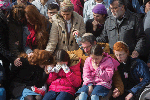 The husband and children of Dafna Meir grieving at her funeral in Jerusalem the day after her stabbing death in the West Bank on Jan. 18. (Photo: Yonatan Sindel / Flash 90)