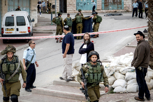 Israeli soldiers removing the body of a Palestinian man who stabbed a soldier in the West Bank city of Hebron on March 24. (Photo: Wissam Hashlamon / Flash 90)