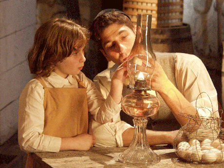 Young Ida Sokoloff (Abby Kozberg) helps her father, Schlomo (Jeffrey Richman), candle eggs. (Photo: David McGrath)