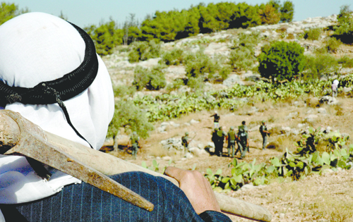 A Palestinian farmer in Budrus watches a group of Israeli soldiers. (Photo: Courtesy of Just Vision)