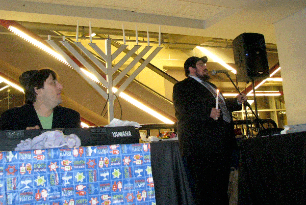 Jeff Victor (left) provided musical accompaniment to the Hanuka candle lighting blessings, which were led by Rabbi Mendel Feller, of Chabad-Lubavitch. (Photos: Mordecai Specktor)