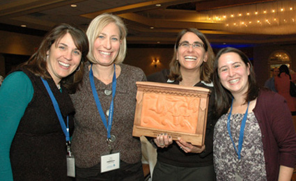 Herzl Camp staff and volunteers proudly display the Impact in Technology Award at the Grinspoon Institute’s ninth annual Camping Conference. Pictured above are (l to r): Lauren Kaplan, immediate past president; Sue Roether, president; Anne Hope, camp director; and Drea Lear, program coordinator. (Photo: Courtesy of Herzl Camp)