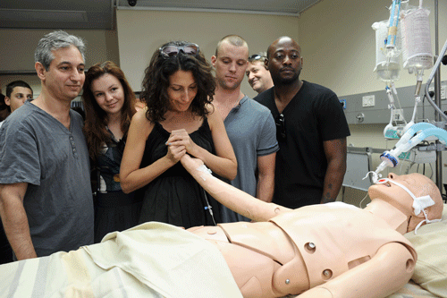Lisa Edelstein, a star of the hit television show House, jokingly comforts a dummy used in medical simulations at the Sheba Medical Center, an Israeli hospital outside of Tel Aviv alongside fellow cast members and the series creator. (Photo: Jorge Novominsky)