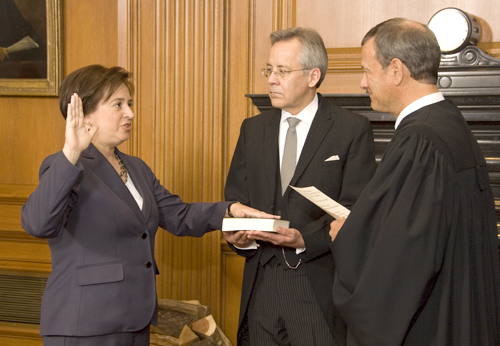 Supreme Court Chief Justice John Roberts administers the constitutional oath to Elena Kagan in the justices conference room as Jeffrey Minear, counselor to the chief justice, holds the Bible, on Aug. 7. (Photo: Steve Petteway, Collection of the Supreme Court of the United States)
