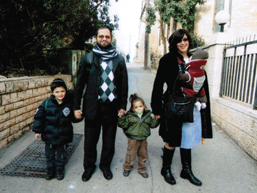 Rabbi Jonathan Sandler and his two sons, Arieh (left), and Gabriel, were killed in the shooting at the Ozar Hatorah School in Toulouse, France. The rabbis wife is holding their daughter. (Photo: Flash90 / JTA)