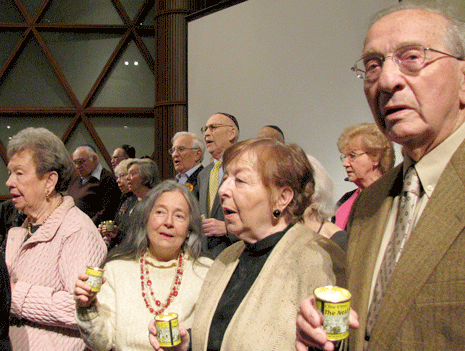At the conclusion of the program, Holocaust survivors were called to the bima, presented with yahrzeit candles and joined in singing the Israeli national anthem, Hatikvah. (Photo: Mordecai Specktor)