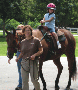 Janet Weisberg, owner and director of Hold Your Horses, LLC, leads six-year-old Dinah Hunegs, who suffers from apraxia. (Photo: Courtesy of Janet Weisberg)